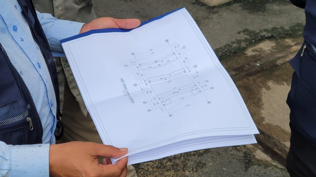 Nhân viên giám sát thi công xem xét lại mặt bằng chi tiết